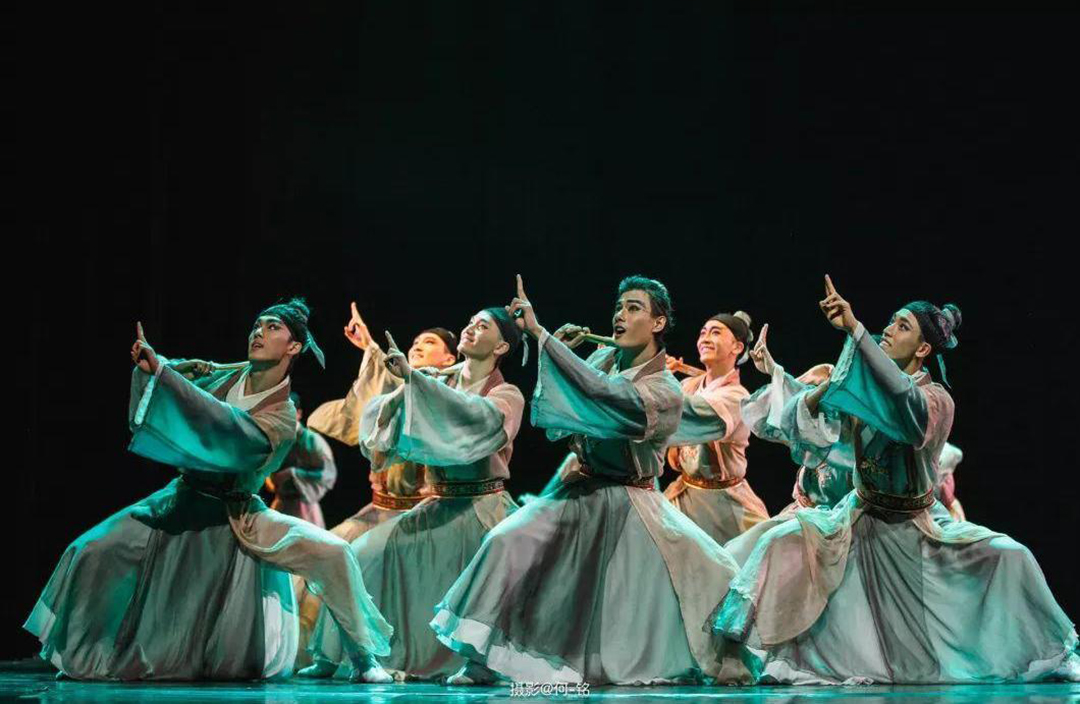 Male dancers in a group performing.